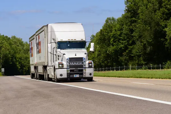 stock image Knoxville, TN, United States  August 20, 2024: horizontal shot of a red eighteen wheeler semi on an interstate highway in the summer heat. Heat waves rising from the hot asphalt creates a blurring effect on background trucks and foreground pavement.