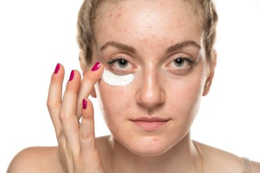 Genç bir kadının kozmetik ürünlerini gözünün altına sürerken yakın çekim görüntüsü..