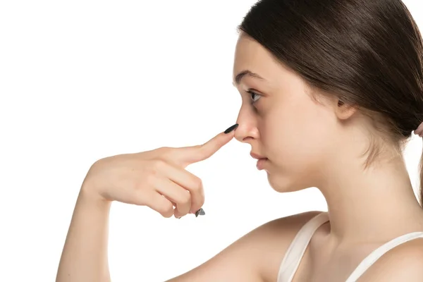 Genç Mutsuz Kadın Beyaz Stüdyo Arka Planında Parmaklarıyla Burnuna Dokunuyor — Stok fotoğraf
