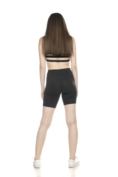 Visão Traseira Uma Jovem Mulher Shorts Pretos Posando Topo Estúdio — Fotografia de Stock