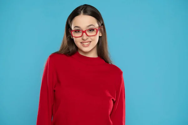 可愛いです女の子で赤ブラウスと眼鏡で隔離されたブルースタジオの背景 — ストック写真