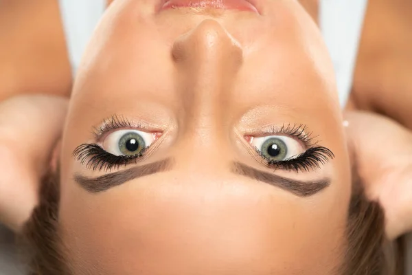 Beauty female eyes with curl long false eyelashes on a white studio background