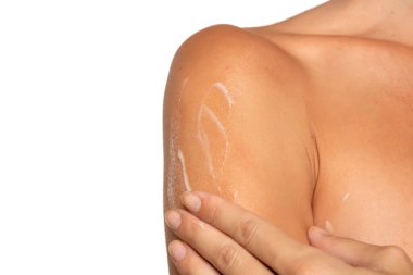 Beyaz stüdyo arka planına krem sürmüş genç bir kadın.