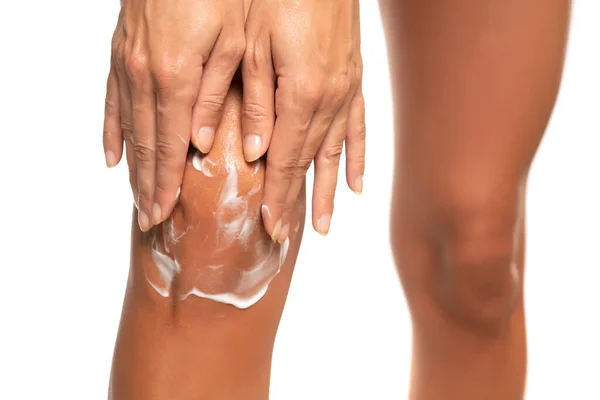 Vrouw Aanbrengen Van Moisturizer Crème Knie Geïsoleerd Witte Achtergrond — Stockfoto