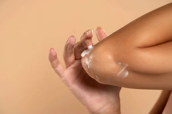 Närbild Kvinna Tar Hand Sina Armbågar Med Kosmetisk Kräm Beige — Stockfoto