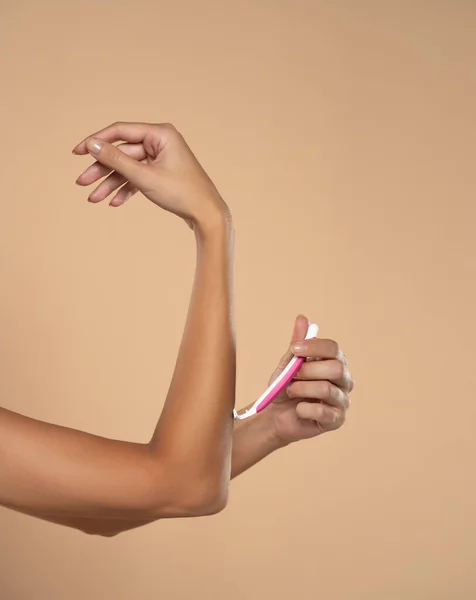 Woman Shaves Her Arms Disposable Pink Razor Beige Studio Background — Stock Photo, Image