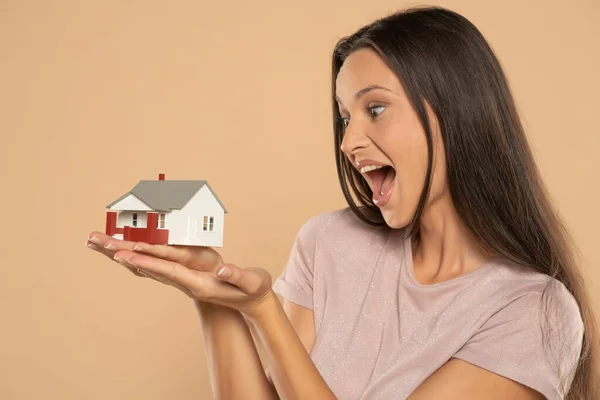 Young Woman Smiling Holding House Sample Model Isolated Beige Studio — Stockfoto