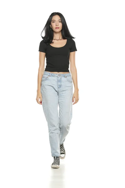 Young Beautiful Woman Loose Jeans Walking White Studio Background — Stockfoto