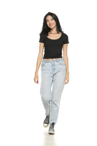Junge Schöne Lächelnde Frau Lockeren Jeans Fuß Auf Weißem Studiohintergrund — Stockfoto