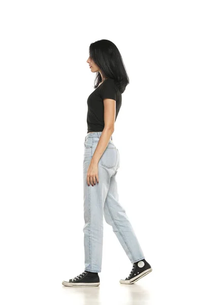 Side View Young Woman Loose Jeans Walking White Studio Background — Stockfoto
