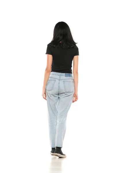 Back View Young Woman Loose Jeans Walking White Studio Background — Stockfoto