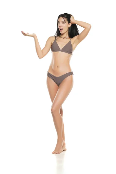 Joven Mujer Morena Sonriente Bikini Traje Baño Publicidad Objeto Imaginario —  Fotos de Stock