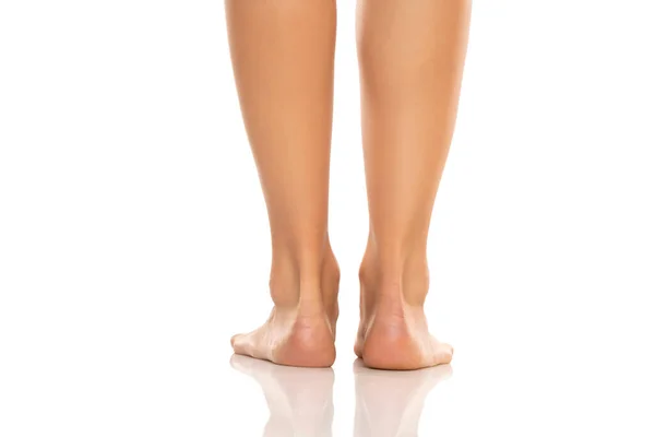 白いスタジオの背景に美しく手入れされた女性の裸の足のバックビュー — ストック写真