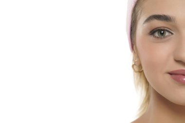 Beyaz bir stüdyonun arka planında gülümseyen güzel bir kadının yarım portresini kapat.