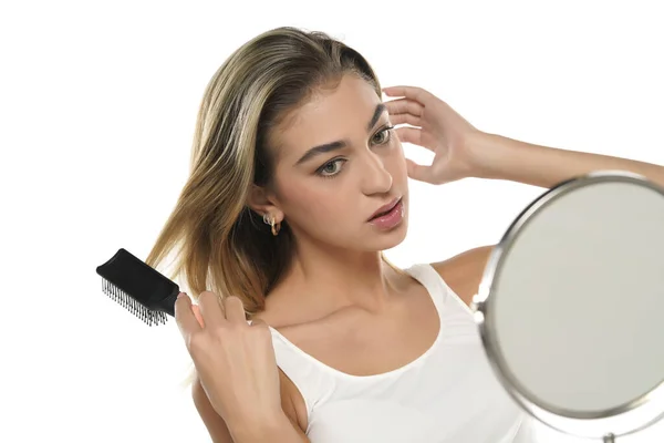 Jovem Mulher Escovando Cabelo Saudável Frente Espelho Fundo Estúdio Branco — Fotografia de Stock
