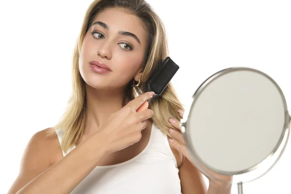 Mujer Joven Cepillando Cabello Sano Delante Espejo Sobre Fondo Blanco — Foto de Stock