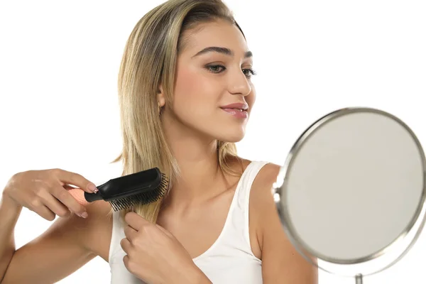 Jovem Mulher Escovando Cabelo Saudável Frente Espelho Fundo Estúdio Branco — Fotografia de Stock