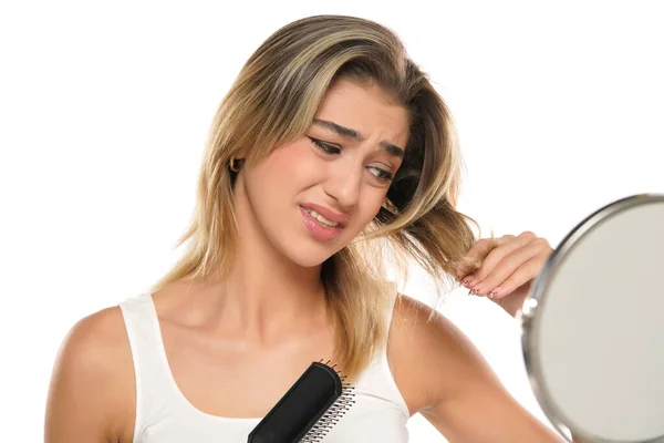 Young Gugup Wanita Menggosok Rambut Depan Cermin Latar Belakang Studio — Stok Foto
