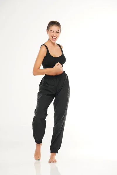 Una Joven Mujer Feliz Descalza Pantalones Chándal Negros Una Camiseta —  Fotos de Stock