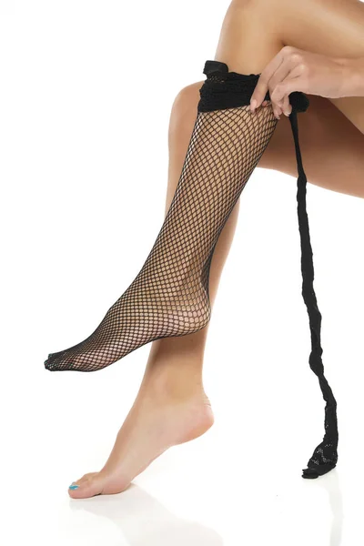 Woman Putting Black Fishnet Stockings White Studio Background — Stock Photo, Image