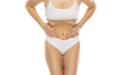 Jinekoloji konsepti. Acı çeken genç bir kadın, beyaz stüdyo geçmişi var.