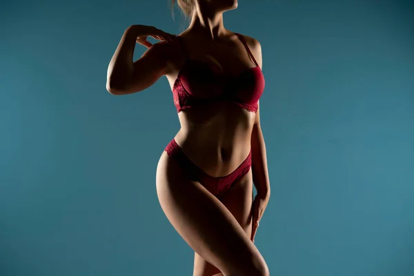 晒黑了的女人在最上面的形状 完美的身体在阴影中的形状 穿着红色内裤 前视镜 蓝色工作室背景的女性身体部位 — 图库照片