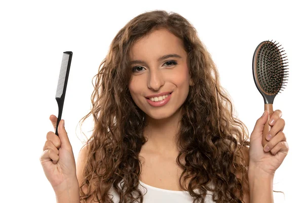 年轻的微笑的女人选择刷子或梳子 美丽或方便 长发的概念 白工作室背景 — 图库照片