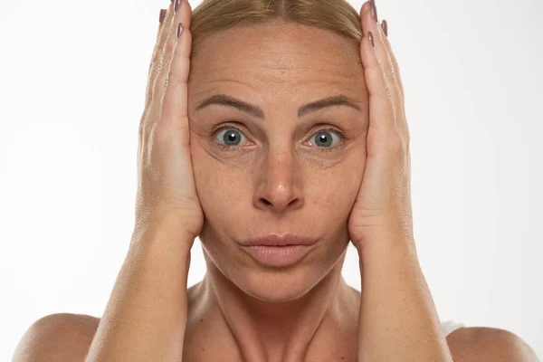 Blonde Frau Mittleren Alters Strafft Ihr Gesicht Mit Ihren Händen — Stockfoto