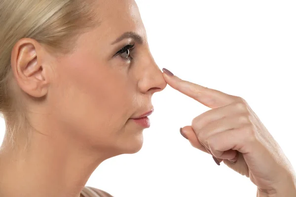 Profile Middle Aged Serious Woman Touchinf Her Nose White Studio — Stock Photo, Image