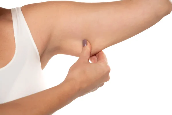 一个中年妇女用她的上臂抓取皮肤 在白色的工作室背景下与多余的脂肪隔离 刺痛松弛松弛的肌肉 超重的概念 — 图库照片