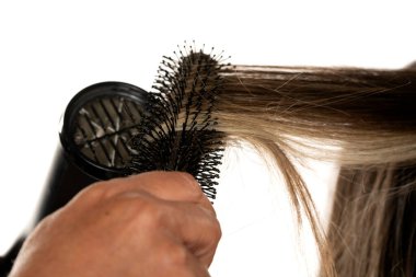 Stüdyoda bir kuaförün saçını beyazların arka planında kuruturken.