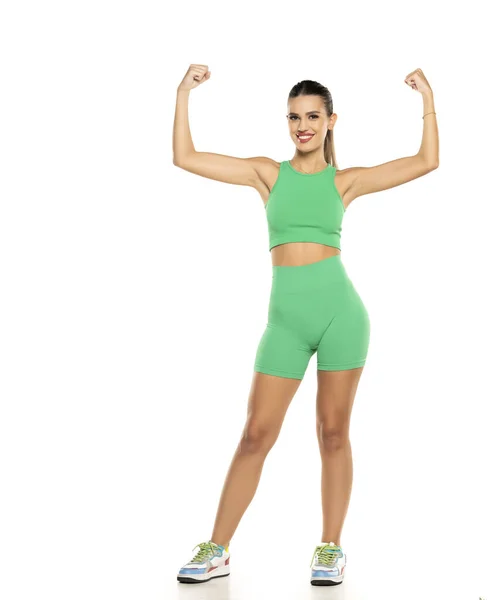 Joven Mujer Sonriente Deportiva Pantalones Cortos Verdes Parte Superior Mostrando —  Fotos de Stock
