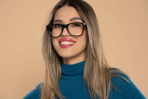 年轻的微笑女性 身穿休闲装 戴着眼镜 在米色工作室的背景下 带着自然的面容和自信的微笑 放松自己的形象 — 图库照片