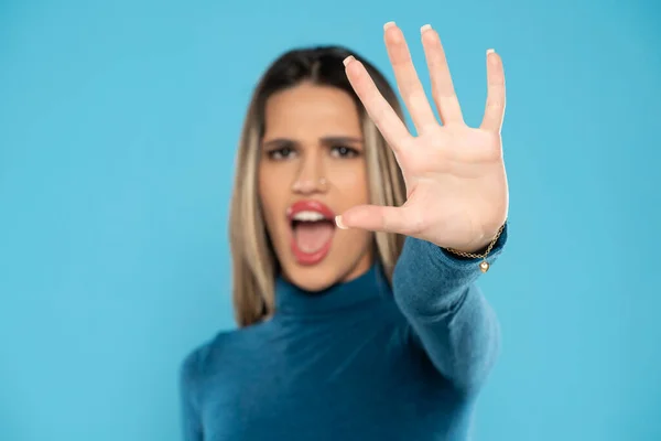 怖い若い叫び 青いスタジオの背景に彼女の手で停止記号を示します — ストック写真