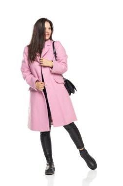 Kışlık ceketli ve beyaz arka planda siyah kot giyen genç bir kadının ön görüntüsü.