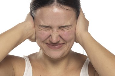 Beyaz bir stüdyo arka planında gürültüye dayanan genç bir kadın.