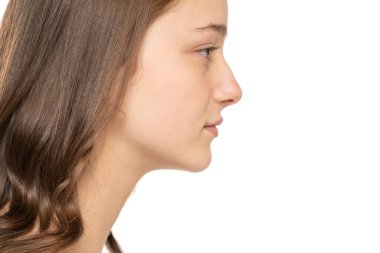 Beyaz stüdyo geçmişinde makyajı olmayan güzel genç bir kadının profili..