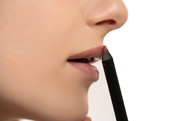 Lips of beautiful young woman applying makeup, closeup