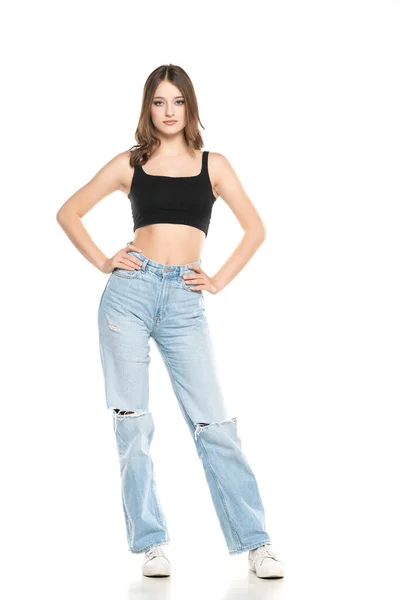年轻的女模特穿着撕破的牛仔裤和黑色无袖衬衫 摆出一副白色的工作室背景 — 图库照片