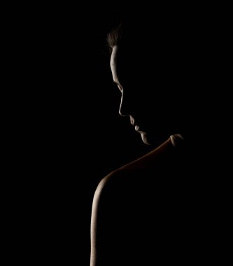 Siyah bir stüdyonun arka planında güzel bir kadının şehvetli silüeti.