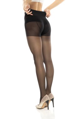 Kadın güzel uzun bacaklarına siyah çorap giyer, beyaz stüdyo arka planında izole olur.