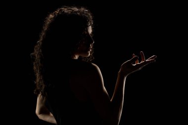 Güzel kıvırcık bir kadının şehvetli portresi arka planda uzanmış siyah bir stüdyonun arka planında.