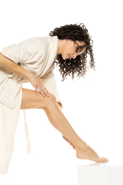 Beautiful Curly Woman Applying Cream Her Legs White Studio Background — Stock Photo, Image