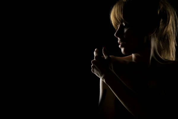 Siluet Seorang Wanita Muda Menyentuh Bahunya Pada Latar Belakang Studio — Stok Foto