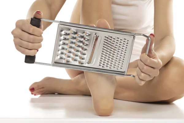 Woman Scrapes Her Feet Kitchen Grater White Studio Background — Stock Photo, Image
