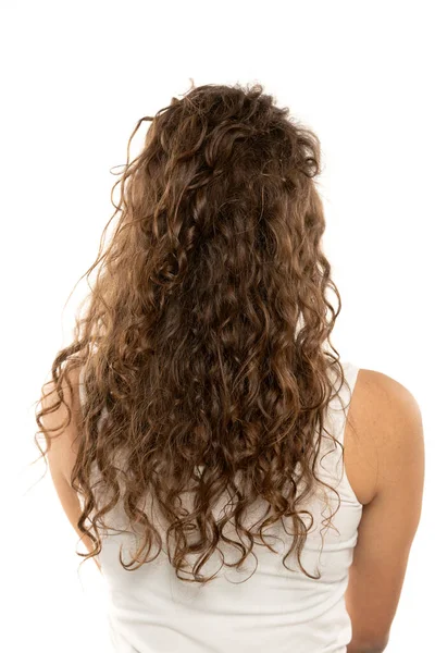白いスタジオの背景に長い茶色の波髪の女性のリアビュー — ストック写真
