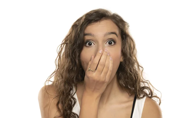 Σοκαρισμένη Νεαρή Γυναίκα Που Καλύπτει Στόμα Χέρι Λευκό Φόντο Στούντιο — Φωτογραφία Αρχείου