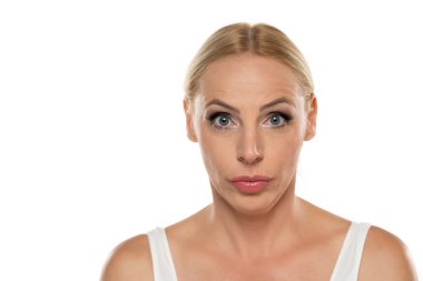 Beyaz stüdyo arka planında makyajlı orta yaşlı sarışın bir kadının portresi.