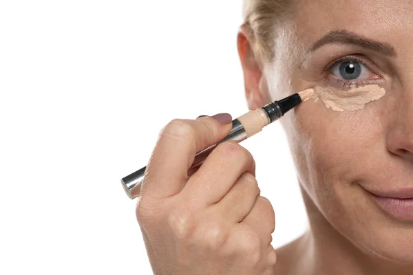 Middle Aged Senior Woman Applyes Concealer Her Eyes White Studio — Stock Photo, Image