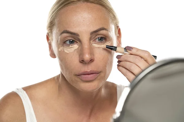 Middle Aged Senior Woman Applyes Concealer Her Eyes White Studio — Stock Photo, Image